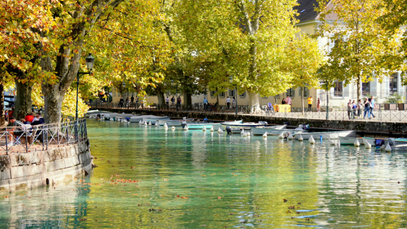 Canal du Vassé et Pont des Amours à Annecy en automne, barques sur le canal et arbres aux feuilles dorées